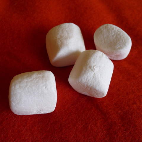 Four marshmallows on an orange cloth