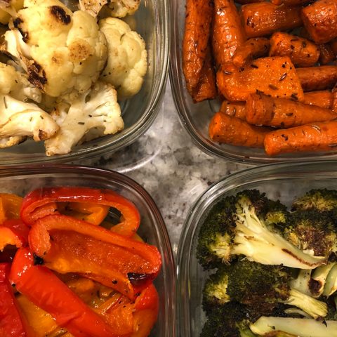 Roasted vegetables in glass containers: cauliflower, carrots, red peppers and broccoli