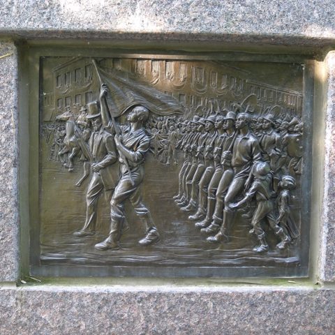 Panel from The Black Brigade memorial, showing The Black Brigade in a parade in downtown Cincinnati