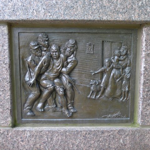 Panel from The Black Brigade memorial, showing a Black man being hauled from his home, while his wife and children look on in horror