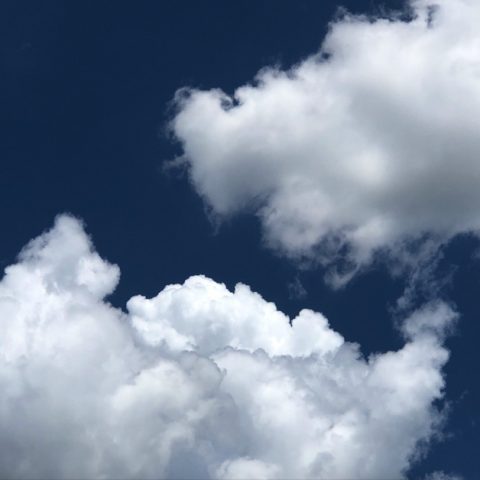 two bright white clouds on a dark blue sky