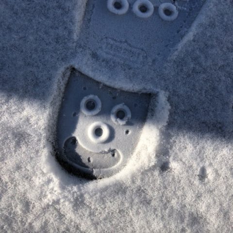 bootprint in snow, with a smiling face on the heel