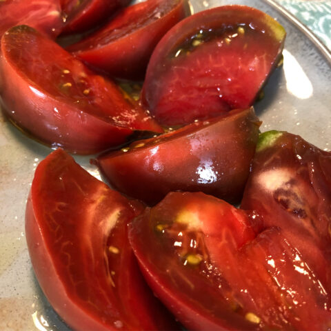 Sliced heirloom tomatoes, glistening with olive oil