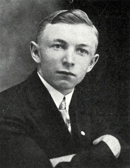Photo of Albin Folda, wearing a dark suit, white shirt, and tie.