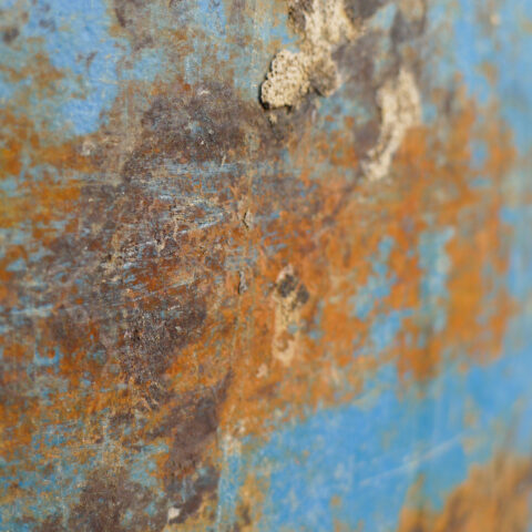 orange-brown rust on blue metal