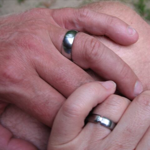 Trent's and Jule's hand with titanium wedding rings