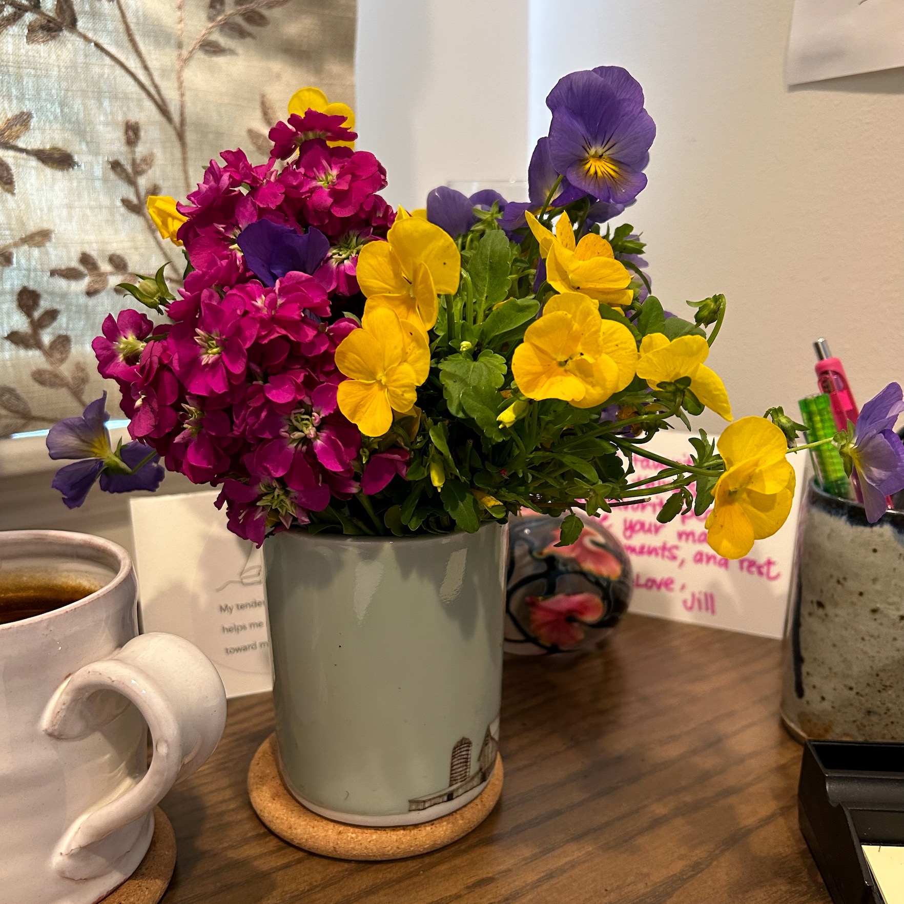 small spring flowers in a vase on a desk