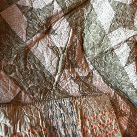 Handmade quilt in sage green, white, and apricot