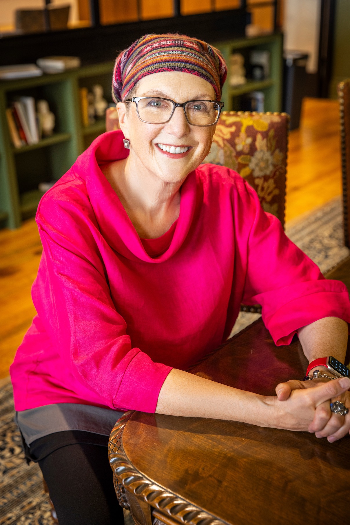 Jule seated at a library table, smiling