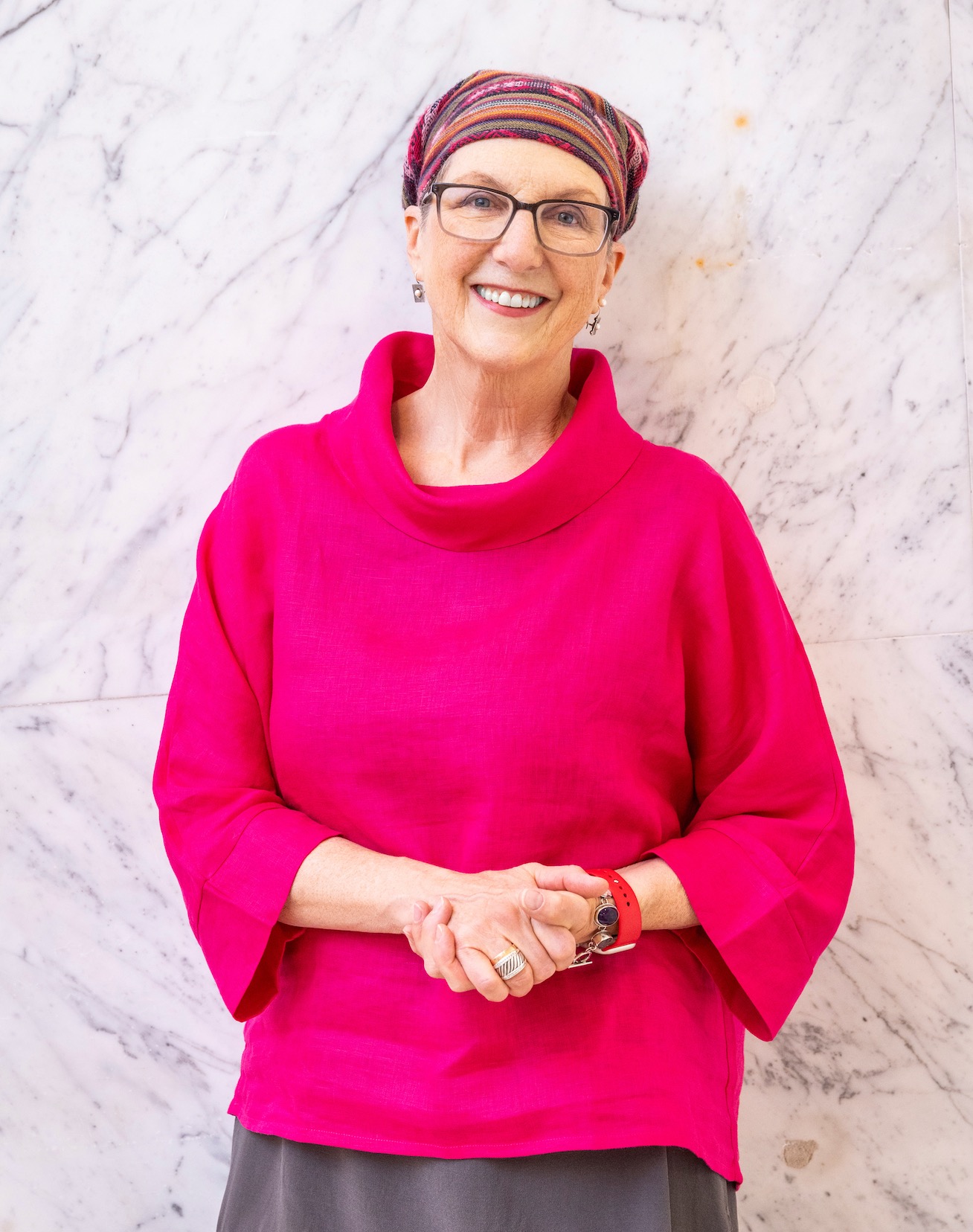 PinkshirtonMarble_654x828 Jule in a magenta linen top, standing in front of a white marble wall
