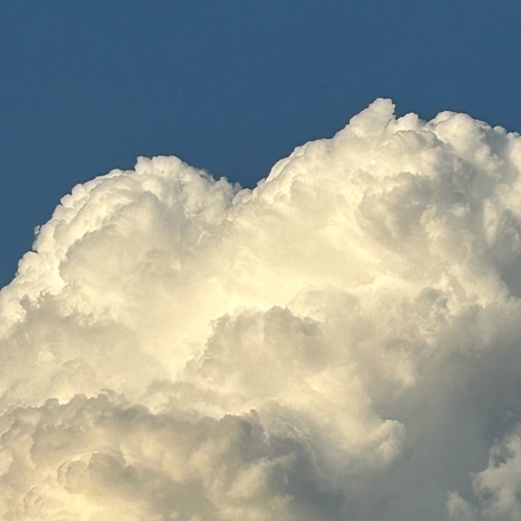 Blue sky with a cloud at the bottom, a heart shape emerging at the top